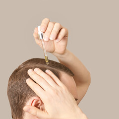 Man baldness treatment. Nature hair care procedure. Oil drop at scalp. Male person applying...