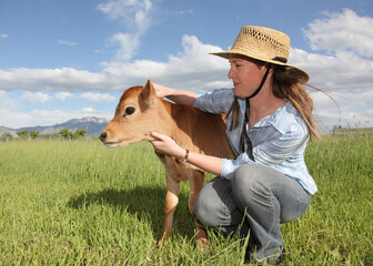farm woman holding baby jersey calf © Nathan Allred