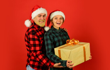 Gift for whole family. Family shopping. Surprise for spouse. Buy present. Christmas party. Christmas time. Man and woman christmas holiday celebration. Giving present. Love and care. Spread love