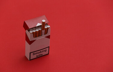 Ppack of cigarettes on red background. Smoking kills.