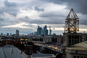 Fototapeta premium cityscape with modern buildings and highways against the backdrop of the river and the setting sun