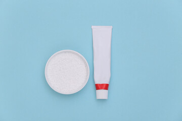 Dental care. Tube of toothpaste and tooth powder on blue background.