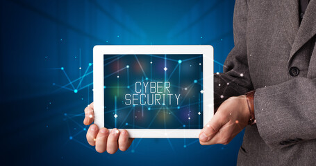 Young business person working on tablet and shows the digital sign: CYBER SECURITY