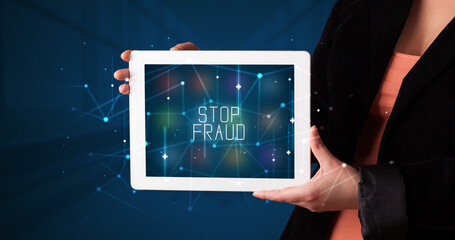 Young business person working on tablet and shows the digital sign: STOP FRAUD