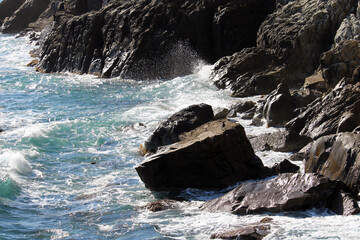 Mareggiata sugli scogli con spruzzi e schiuma