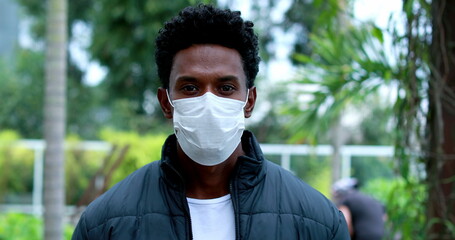 African man walking wearing pandemic mask portrait.