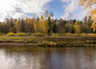 Fototapeta na wymiar autumn landscape with colorful trees on the river bank, expressive sky