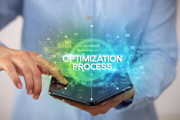 Businessman holding a foldable smartphone with OPTIMIZATION PROCESS inscription, new business concept