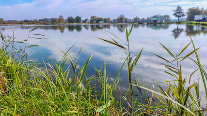 Sunny day on the perfect lake. Autumn lake with reflection on the water. Cloudy sky in the sunny day.