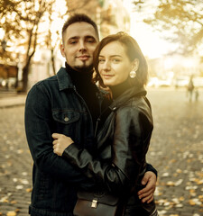 Fototapeta premium Young couple in love hugs and spend time together in the city against the backdrop of urban architecture.