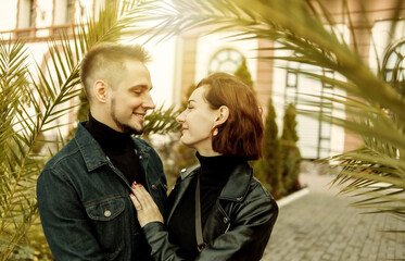 Young couple in love hugs and spend time together in the city against the backdrop of urban architecture. - Powered by Adobe