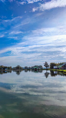 Sunny day on the perfect lake. Autumn lake with reflection on the water. Cloudy sky in the sunny day.