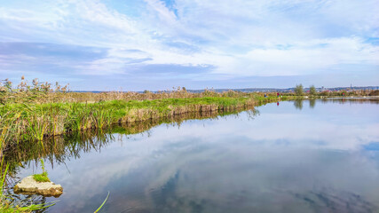 Sunny day on the perfect lake. Autumn lake with reflection on the water. Cloudy sky in the sunny day.