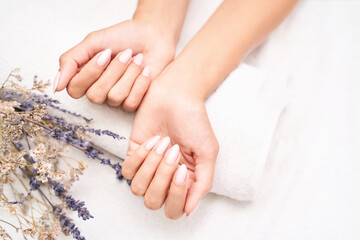 Classic pink wedding nail manicure on white backdrop. Spa treatment concept. Towel background....