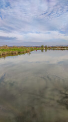 Sunny day on the perfect lake. Autumn lake with reflection on the water. Cloudy sky in the sunny day.