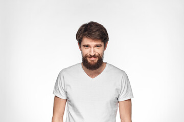 Fototapeta premium Bearded man in white t-shirt gesture with hands emotions light background