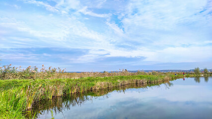 Sunny day on the perfect lake. Autumn lake with reflection on the water. Cloudy sky in the sunny day.