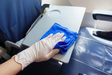 Close up hand is wearing gloves cleaning aircraft for covid-19 prevention pandemic