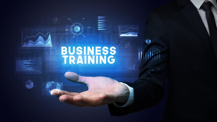 Hand of Businessman holding BUSINESS TRAINING inscription, business success concept