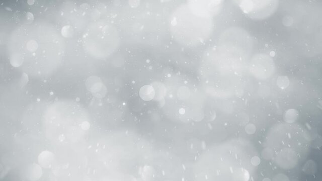 Beautiful silver colored blurry circle bokeh with realistic snow falling background. Christmas and New Year copy space decoration animation.	