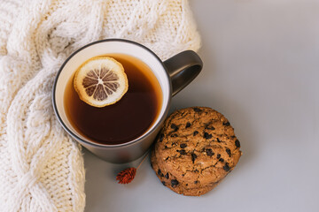 Autumn tea. Sweater, maple leaves, cookies and cup of tea with lemon.