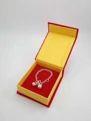 Red and yellow box case with silver chain bells wrist jewellry