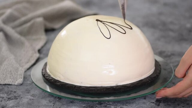 Pouring melted chocolate on top of a cake. Pancho cake with pineapple and sour cream topped with chocolate and nuts.