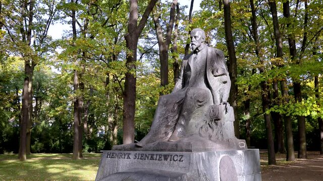 4k footage of polish writer Henryk Sienkiewicz monument in Lazienki Krolweskie, Royal Baths Park in Warsaw city, Poland