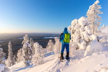 Foto auf Alu-Dibond Hiker on snowshoes amongst frozen trees near Pyha in Lapland, Finland © adammajor
