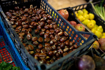 At the greengrocer, chestnuts in the basket. Seasonable fruit at the market. Close up shot