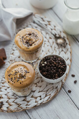 Dalgona whipped coffee, instant, cream, iced coffee. Cocktail with coffee, milk and ice cubes on light background mockup. Trendy drink background with copy space for text.
