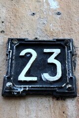 plaque on the wall of the house with the number 23