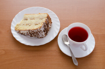 One white cup of tea and cake.