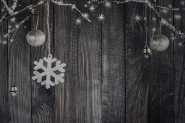 Copo de nieve, bolas de navidad, campana y estrellas sobre fondo de madera gris oscuro