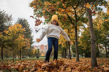 Happy children walk in autumn park. leaf fall, lifestyle