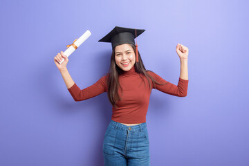 Portrait of young University student woman with graduation cap on violet background