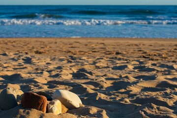 formation of stones on the beach during the sunrise with blurred sea in the background