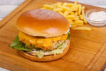 Homemade burger with fish, cheese and salad leaves