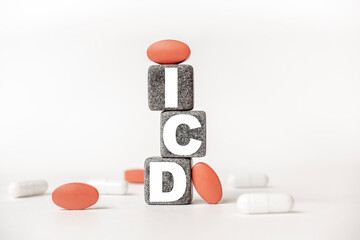 a group of white and red pills and cubes with the word ICD Implantable cardioverter defibrillator on them, white background. Concept carehealth, treatment, therapy.
