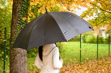 Young woman with umbrella. Walk under the rain.
