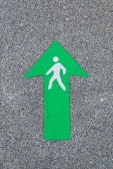green arrow drawn with a drawing of a person on grey marble