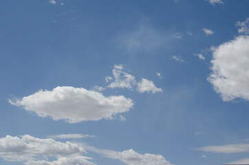 Naklejka na ściany i meble White clouds on a blue sky. Background.