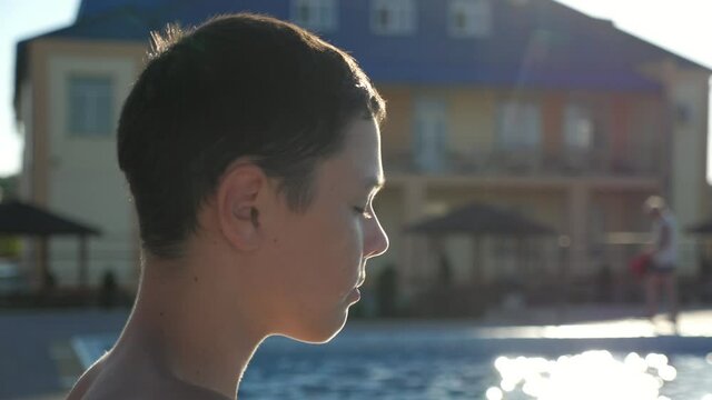 Young guy putting on mask and showing two thumb up gestures at a pool in slo-mo
