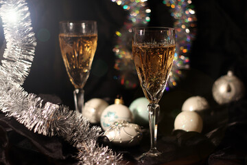 Two glasses of Champagne, sparkler and christmas decorations. Holiday atmosphere. Bokeh. Out of focus background. Merry Christmas and Happy New Year!