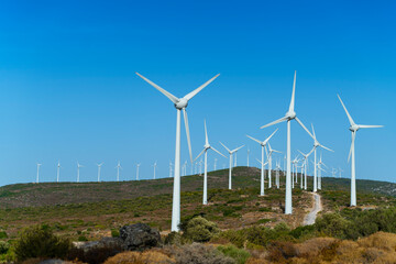 Fototapeta premium Aerial view large group of eco system wind turbines power generation station on green field in rural landscape in countryside