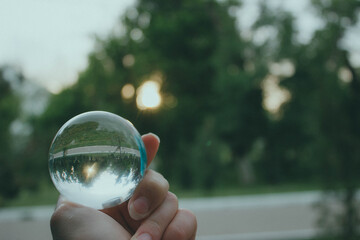 person holding a glass sphere