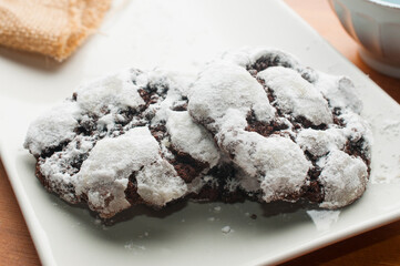 Three double chocolate crinkle cookies on white plate