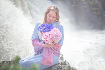 girl with a bouquet of hydrangeas walks on the shore, spring photo session