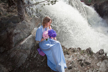 girl with a bouquet of hydrangeas walks on the shore, spring photo session