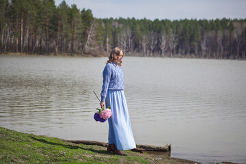girl with a bouquet of hydrangeas walks on the shore, spring photo session